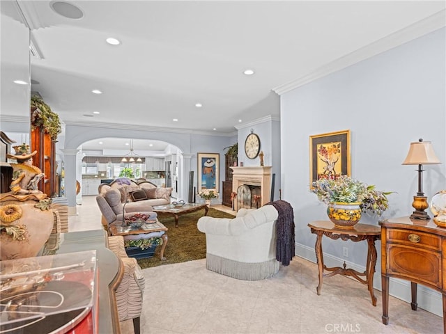 living area with decorative columns, arched walkways, ornamental molding, a fireplace, and recessed lighting