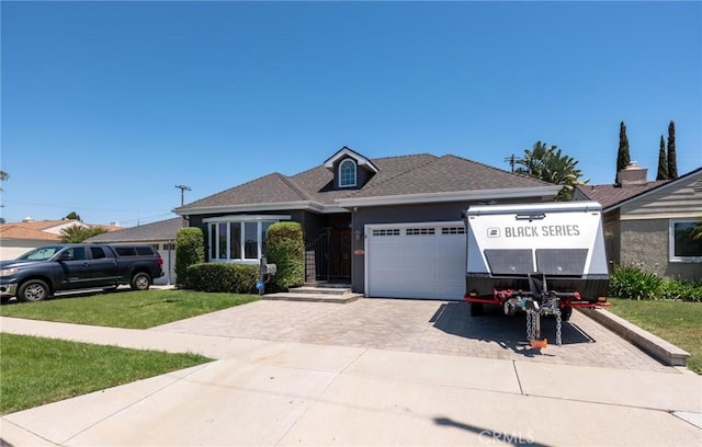 view of front of home with a garage, driveway, a front lawn, and roof with shingles
