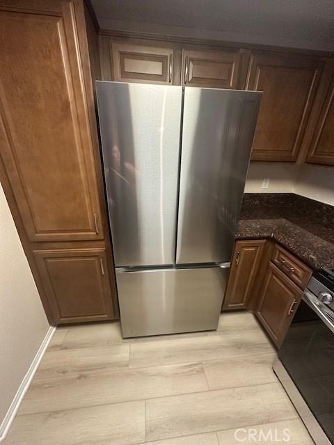 31256 Taylor Ln, Temecula, CA 92592 - kitchen with appliances with stainless steel finishes, light wood finished floors, dark stone countertops, and baseboards