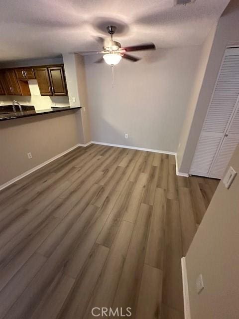 31256 Taylor Ln, Temecula, CA 92592 - unfurnished living room with a ceiling fan, dark wood-style floors, baseboards, and a sink
