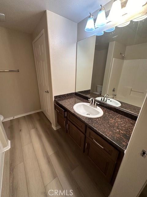 31256 Taylor Ln, Temecula, CA 92592 - full bath with wood finished floors, toilet, vanity, a shower, and baseboards