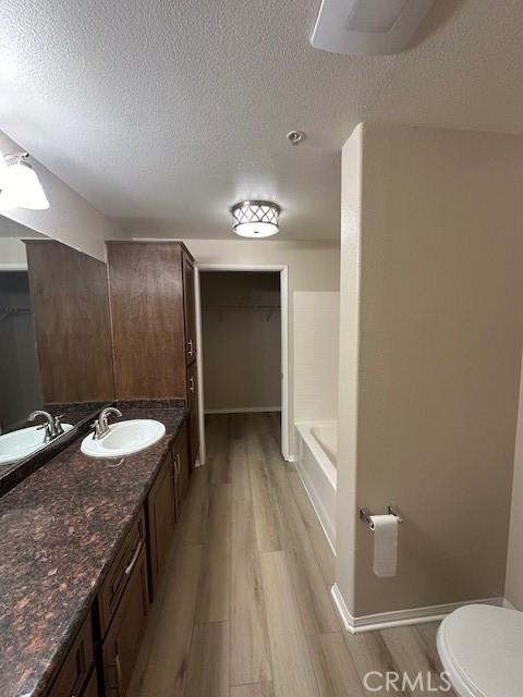 31256 Taylor Ln, Temecula, CA 92592 - full bathroom with a textured ceiling, wood finished floors, vanity, toilet, and a shower