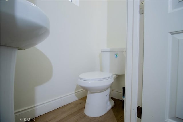bathroom featuring wood finished floors and toilet