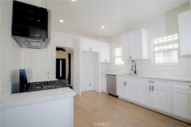kitchen featuring dishwasher, a sink, white cabinetry, and recessed lighting