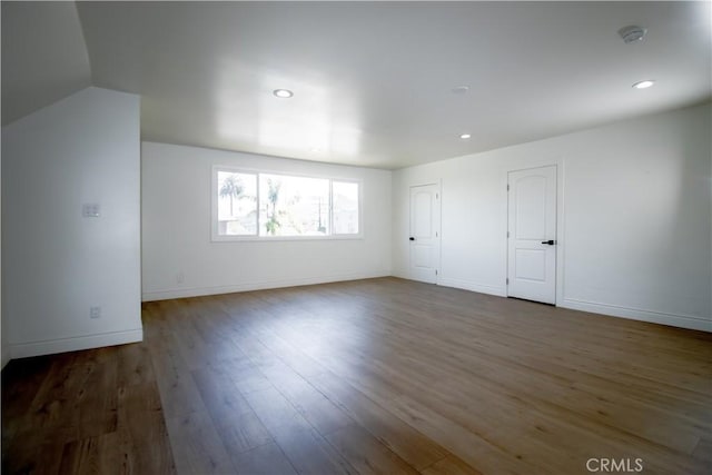 empty room with wood finished floors, baseboards, recessed lighting, and a smoke detector