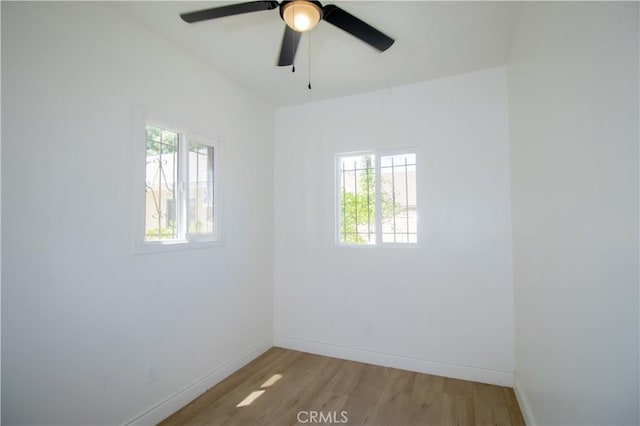 spare room with healthy amount of natural light, baseboards, light wood-style floors, and ceiling fan