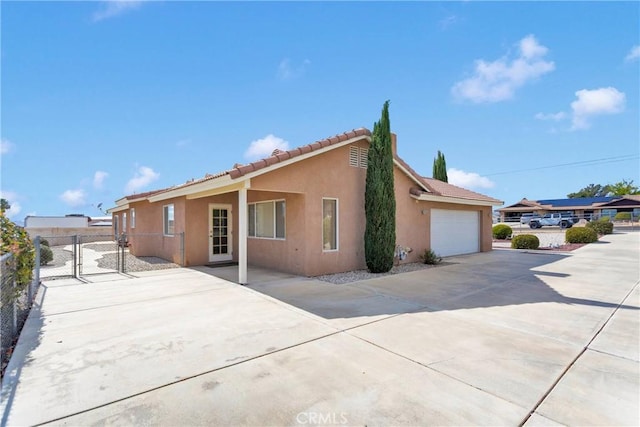 19115 Seneca, Apple Valley, CA 92307 - view of side of property featuring stucco siding, concrete driveway, fence, an attached garage, and a tiled roof