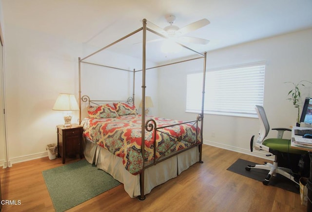 bedroom featuring light wood-type flooring, baseboards, and a ceiling fan