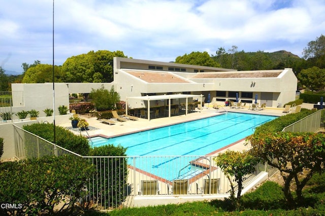 community pool with fence and a patio