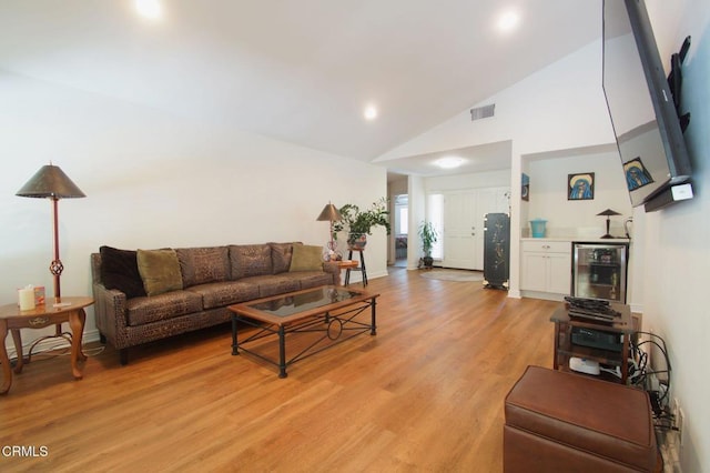 living area with light wood-style floors, beverage cooler, high vaulted ceiling, recessed lighting, and baseboards