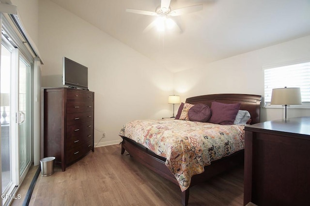 bedroom with light wood-style floors, vaulted ceiling, baseboards, and a ceiling fan