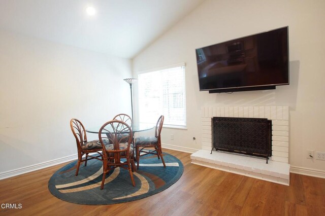 6464 San Como Ln, Camarillo, CA 93012 - dining area featuring baseboards, a fireplace, wood finished floors, and high vaulted ceiling