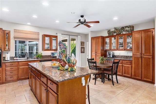 35475 Calendula Cir, Winchester, CA 92596 - kitchen with a sink, brown cabinets, recessed lighting, glass insert cabinets, and a center island