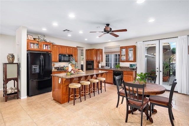 35475 Calendula Cir, Winchester, CA 92596 - kitchen featuring black appliances, brown cabinets, recessed lighting, french doors, and a kitchen island