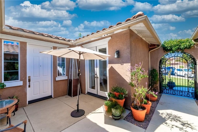 35475 Calendula Cir, Winchester, CA 92596 - view of exterior entry with a gate, stucco siding, a patio, french doors, and fence