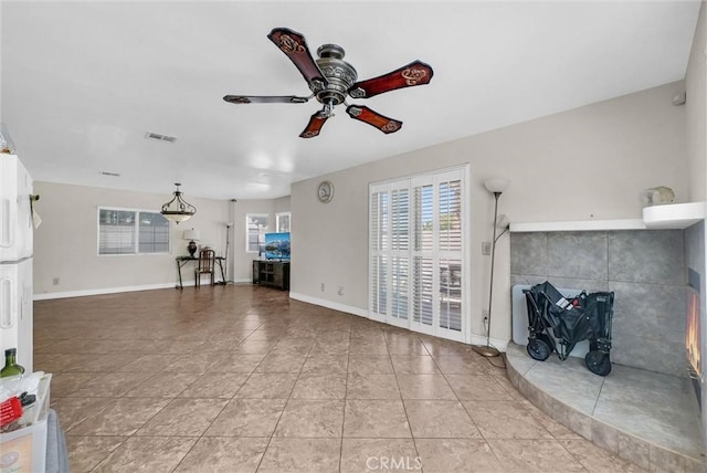 1451 W 10th St, Pomona, CA 91766 - unfurnished living room featuring ceiling fan, plenty of natural light, tile patterned flooring, and baseboards