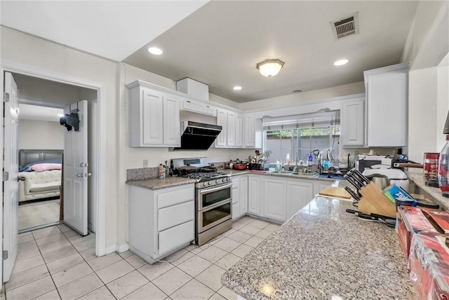 1451 W 10th St, Pomona, CA 91766 - kitchen with double oven range, ventilation hood, light tile patterned floors, white cabinetry, and recessed lighting