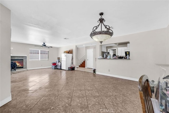 1451 W 10th St, Pomona, CA 91766 - unfurnished living room featuring a ceiling fan, stairway, baseboards, a lit fireplace, and tile patterned floors
