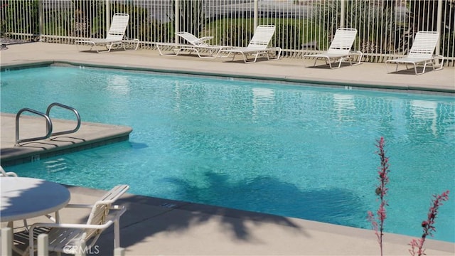 community pool featuring a patio area and fence