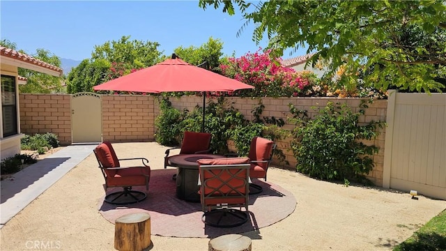 view of patio featuring a fire pit and fence