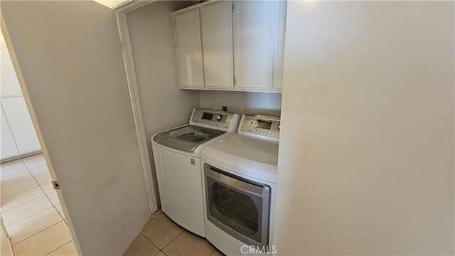 laundry room with cabinet space, independent washer and dryer, and light tile patterned floors