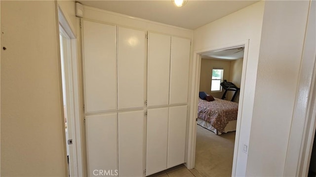 corridor with light colored carpet and light tile patterned floors