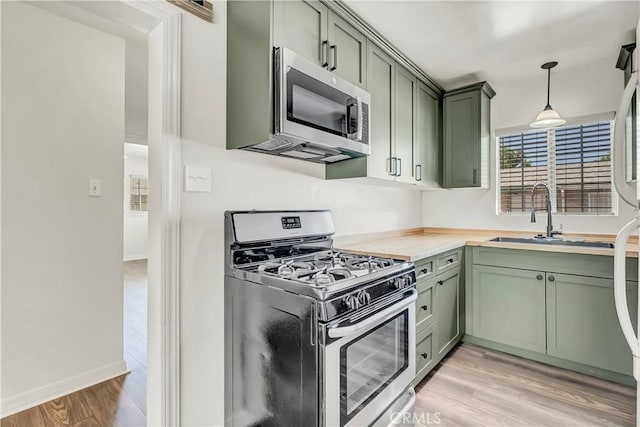 109 Lorita Way, Hanford, CA 93230 - kitchen featuring green cabinets, stainless steel appliances, a sink, light wood-style floors, and light countertops