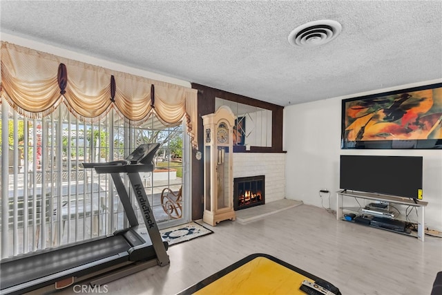 11242 Kamloops St, Sylmar, CA 91342 - exercise room featuring a textured ceiling, wood finished floors, and a fireplace