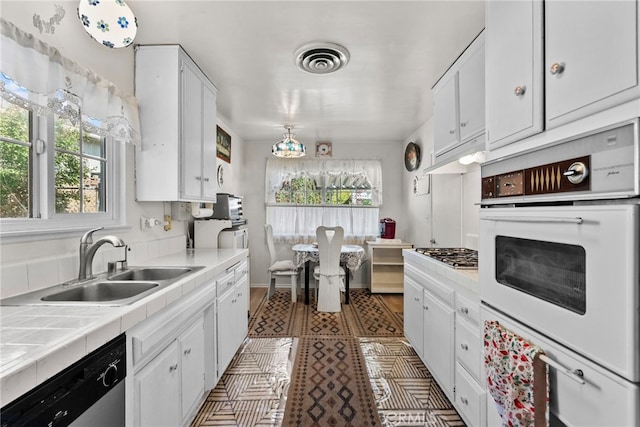 11242 Kamloops St, Sylmar, CA 91342 - kitchen with appliances with stainless steel finishes, a sink, tile counters, and white cabinets