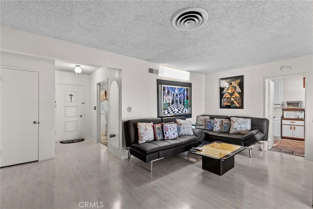 11242 Kamloops St, Sylmar, CA 91342 - living room with wood finished floors, a textured ceiling, and arched walkways