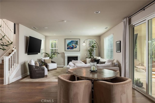 dining space featuring stairs, wood finished floors, baseboards, healthy amount of natural light, and recessed lighting