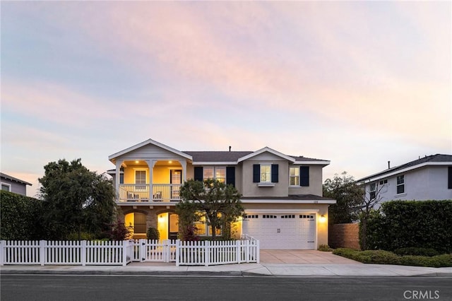 view of front of house featuring stucco siding, driveway, an attached garage, and a fenced front yard