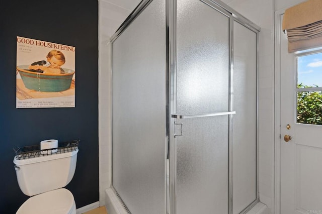 full bathroom featuring a shower stall, toilet, and baseboards