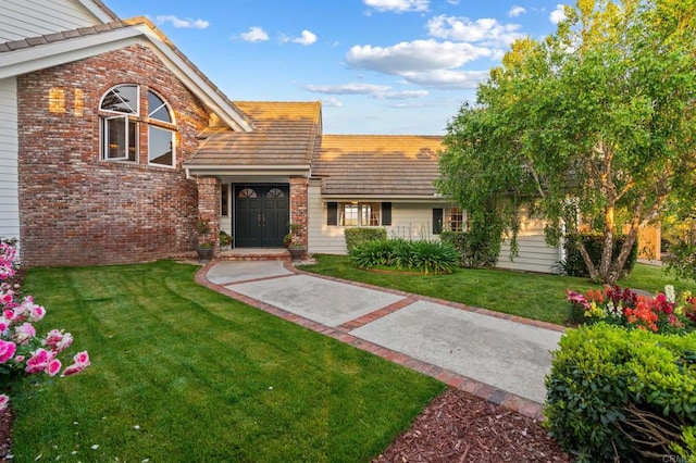view of front of house featuring brick siding and a front lawn