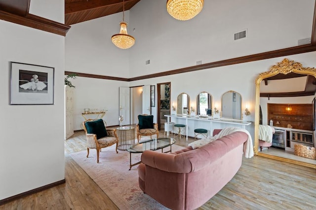 living room with high vaulted ceiling, hardwood / wood-style floors, baseboards, and beam ceiling