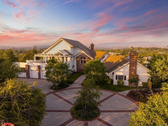 traditional home with a chimney and driveway