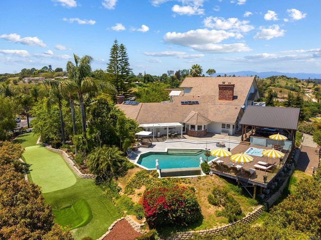 swimming pool featuring a hot tub, a putting area, a gazebo, and a fenced backyard