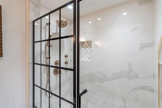 bathroom view of tiled shower and recessed lighting