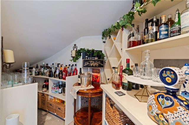 indoor dry bar with vaulted ceiling and finished concrete flooring