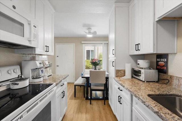 8102 Winter Gardens Blvd Unit 5, Lakeside, CA 92040 - kitchen with white appliances, light wood finished floors, white cabinets, and light stone counters