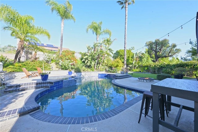 view of pool featuring an outdoor fire pit, a patio area, and a pool with connected hot tub