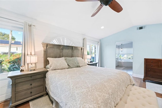 bedroom featuring vaulted ceiling, wood finished floors, ensuite bathroom, and ceiling fan