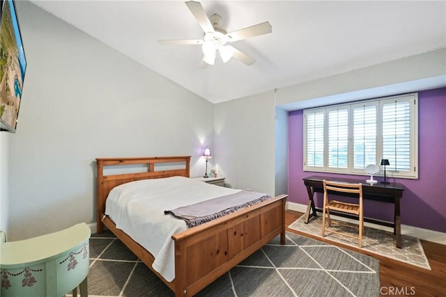 bedroom with baseboards, a ceiling fan, and dark wood finished floors