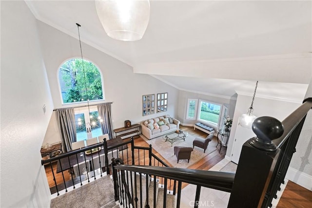 living room with ornamental molding, lofted ceiling, wood finished floors, and baseboards