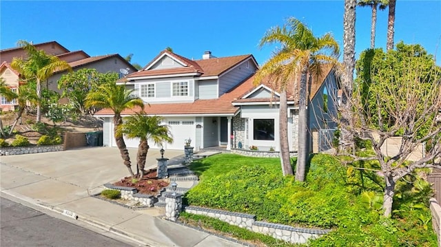 view of front of house with concrete driveway, a garage, and a tile roof
