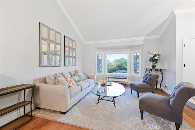 living area featuring wood finished floors, lofted ceiling, and ornamental molding
