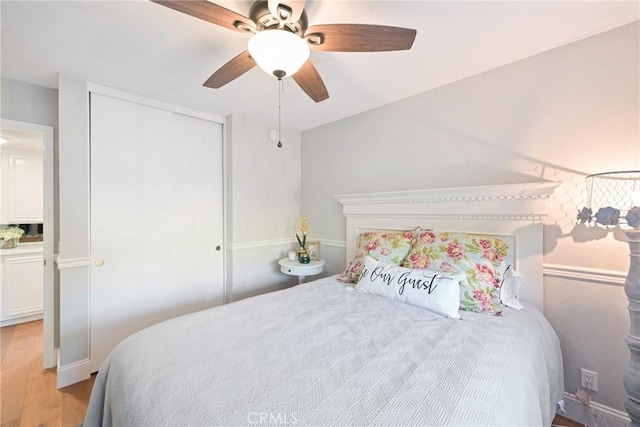 bedroom with light wood-type flooring, a closet, and ceiling fan