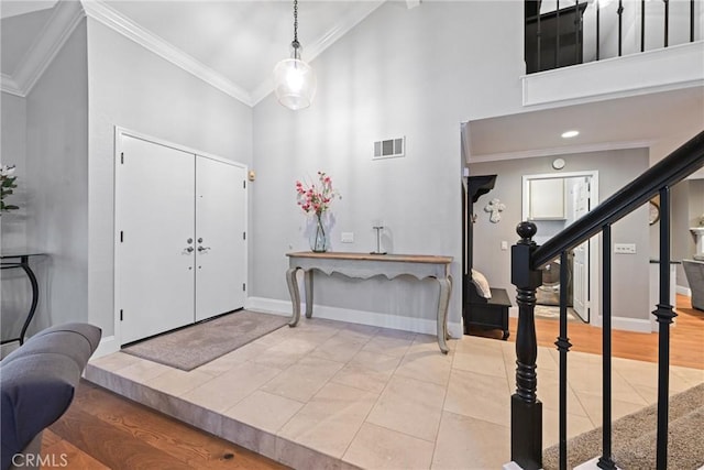 entryway featuring high vaulted ceiling, baseboards, crown molding, stairway, and wood finished floors