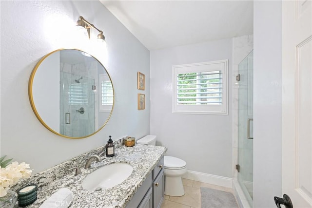 bathroom featuring a shower with door, vanity, toilet, tile patterned floors, and baseboards