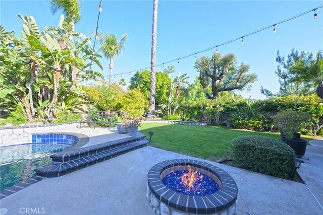 view of patio with a fire pit and an outdoor pool